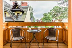 a patio with two chairs and a table on a balcony at Willa Vera Zakopane in Zakopane