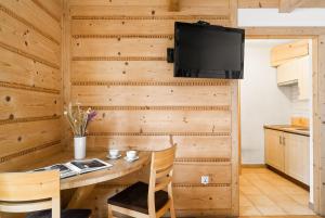 a dining room with a table and a tv on a wall at Willa Vera Zakopane in Zakopane