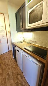 una cucina con lavello e microonde di Val Thorens - Ski InOut - 4 Beds Flat C-E20 a Béranger Altre 8 foto