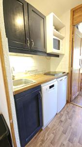una cucina con armadi neri e lavastoviglie bianca di Val Thorens - Ski InOut - 4 Beds Flat C-E20 a Béranger