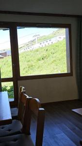 una camera con una grande finestra con sedie e un tavolo di Val Thorens - Ski InOut - 4 Beds Flat C-E20 a Béranger
