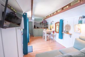 a living room and kitchen in a tiny house at Roulotte avec bain nordique privatif chauffé, Séjour calme et bien-être in Fichous-Riumayou