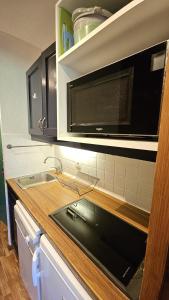 a kitchen with a sink and a microwave at Val Thorens - Ski InOut - 4 Beds Flat C-E19 in Béranger +6 photos