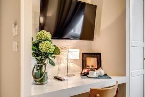 a vase of flowers on a shelf with a mirror at The Club Navona in Rome