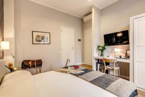 a bedroom with a bed and a desk and a tv at The Club Navona in Rome