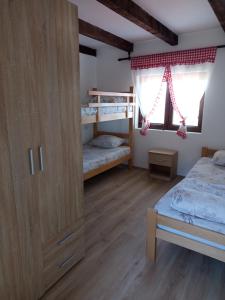 a bedroom with two bunk beds and a window at Etno kuća Ostrvica in Varnice