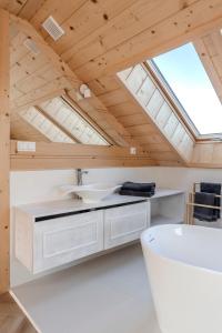 an attic bathroom with a sink and a skylight at Czorna Chata u Chocyków in Czarna Góra +69 photos