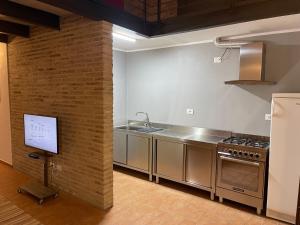 a kitchen with stainless steel appliances and a brick wall at Casavacanzebrunella in Sassoferrato