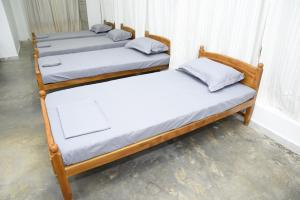 a group of four beds sitting in a room at Colombo Mount Hostel in Mount Lavinia
