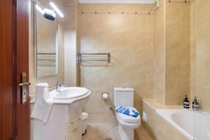 un bagno con lavandino, WC e vasca di Monte Fino Beach a Monte Gordo Altre 19 foto