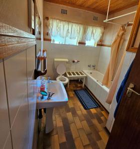 a bathroom with a sink and a toilet and a tub at Home with The Hoffs in Smithfield