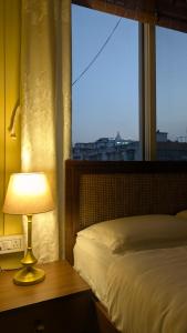 古瓦哈提Seneh Homes Hotel Standard Stay Homely Comfort 2BHK Dispur的一间带床、窗户和灯的卧室