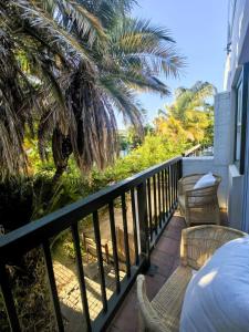 a balcony with a table and chairs and palm trees at Offbeat off Dorp in Stellenbosch