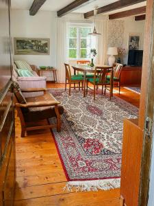 a living room with a table and a dining room at Traditional Red House By The Lake In Småland in Åby