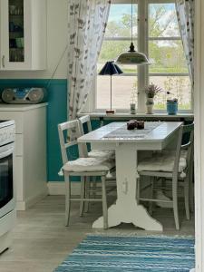 a kitchen with a white table and chairs and a window at Traditional Red House By The Lake In Småland in Åby