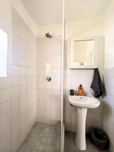 a white bathroom with a sink and a shower at Offbeat off Dorp in Stellenbosch