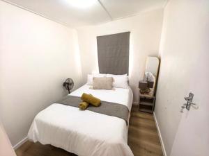 a bedroom with a bed with a yellow stuffed animal on it at Offbeat off Dorp in Stellenbosch