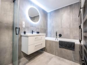 a bathroom with a sink and a tub and a mirror at Ubytování za Řekou in Hořejší Vrchlabí