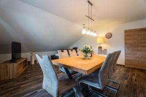 een eetkamer met een houten tafel en stoelen bij Ferienwohnung Wiedergrün in Durbach