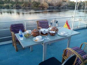 a table on the deck of a boat on the water at Shellaly Ca Nubian Guest2 House in Jazīrat Salūjah
