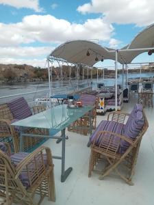 a table and chairs with an umbrella on a boat at Shellaly Ca Nubian Guest2 House in Jazīrat Salūjah
