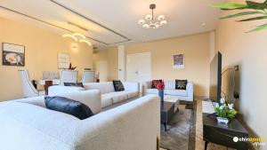 a living room with white couches and a table at Chic apart with parking and rooftop in Yaoundé
