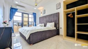 a bedroom with a large bed with a large wooden headboard at Chic apart with parking and rooftop in Yaoundé
