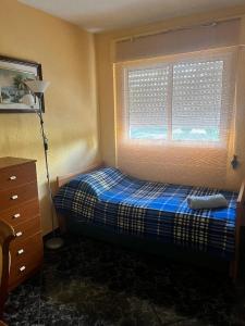 a bedroom with a bed and a window with a blue blanket at Piso Alicante in Alicante +20 photos