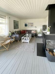 Una sala de estar con un sofá y una chimenea. en Cozy Cabin With Sea View And Two Terraces, en Tjøme 24 fotos más
