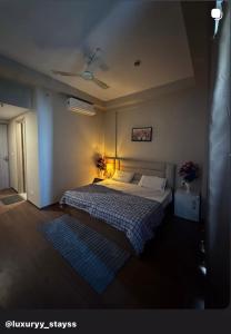 ein Schlafzimmer mit Bett und Deckenventilator in der Unterkunft Luxury stays in Greater Noida