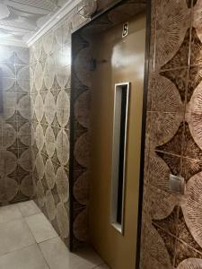 a elevator in a bathroom with a wall of wood slices at Piso Alicante in Alicante +18 photos
