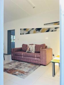 Sunny Snooze Holiday Home في جودوود: غرفة معيشة مع أريكة وسجادة