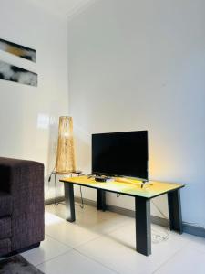 Sunny Snooze Holiday Home في جودوود: مكتب عليه تلفزيون في غرفة المعيشة