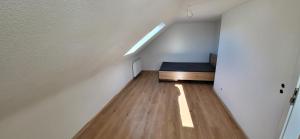 een kleine kamer met een bed op de zolder bij Wunderschönes Haus mit 3 Schlafzimmern in Crailsheim