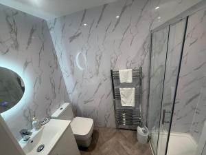 a bathroom with a shower and a toilet and a sink at Rose Cottage by Sasco in Blackpool