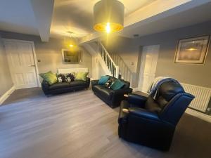 ein Wohnzimmer mit 2 Sofas und einer Treppe in der Unterkunft Rose Cottage by Sasco in Blackpool