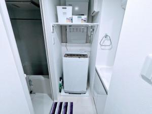 a small kitchen with a stove in a small refrigerator at The Akasaka roppongi Central Stay in Tokyo