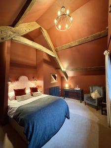 a bedroom with a large bed and a chandelier at Slowley Farm in Watchet