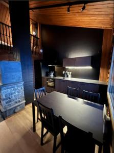 a kitchen with a table and chairs and a kitchen with a stove at Arvoneliöt Lomahimos 17 in Jämsä +4 photos