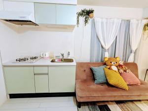 two teddy bears sitting on a couch in a kitchen at The Akasaka roppongi Central Stay in Tokyo