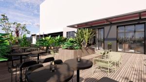 a restaurant with tables and chairs on a deck at Intercity Hotel & Serviced Apartment Phnom Penh Downtown in Phumĭ Prêk Chrey