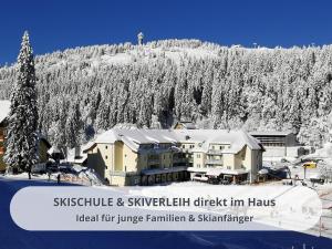 a building on a ski slope with a snow covered mountain at FeWo Schwarzwaldschick Feldberg I Direkt an der Piste I Whirlwanne I Tiefgarage I Skipass vergünstigt in Feldberg