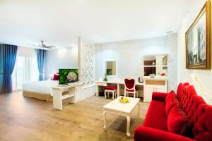 a hotel room with a bed and a red couch at Ladalat Hotel in Da Lat