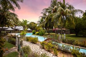 a resort with a swimming pool and palm trees at Three-bedroom at Jardin du Cap with shared pool in Cap Malheureux