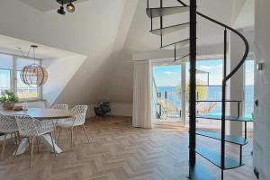 a dining room with a table and a spiral staircase at Lake House 10 - 4 Person Lake view apartment! in Offingawier