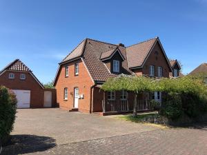 a large brick house with a garage at Adlerhorst - Moderne 60 qm Wohnung mit Terrasse in Oevenum