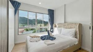 a bedroom with a bed and a large window at Dcondo Kathu - Top Floor 1 Bdr Condo with shared Pool in Kathu +17 photos