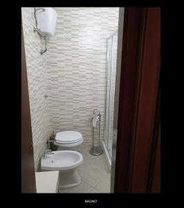 Un pequeño baño con inodoro y ducha. en Greenway, en Quartu Sant'Elena