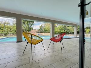 two chairs sitting in front of a swimming pool at Berrybliss Guesthouse - Sandton in Sandton