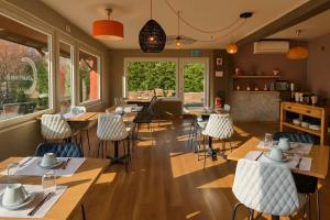 a restaurant with wooden tables and chairs and windows at Hôtel restaurant Relais de Rixheim Ile Napoléon Mulhouse in Rixheim
